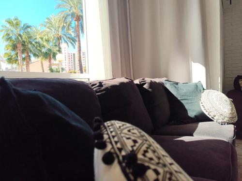sala de estar con sofá con almohadas y ventana en Apartamento en la Playa - Alicante, Costa Blanca - Los Olivos, en Alicante