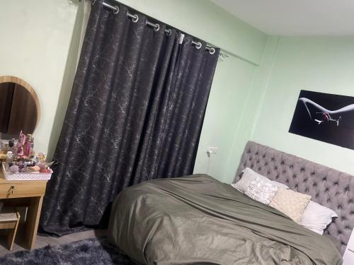 ein Schlafzimmer mit einem Bett und einem schwarzen Vorhang in der Unterkunft Trishas in Bungoma