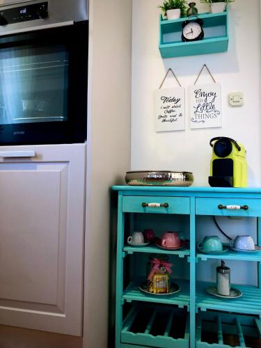 a kitchen with a blue cabinet and a microwave at Odisea Hill House - Modern Holiday Home with swimming pool, sauna, jacuzzi, WiFi and 2 bedrooms, near Varazdin in Gačice