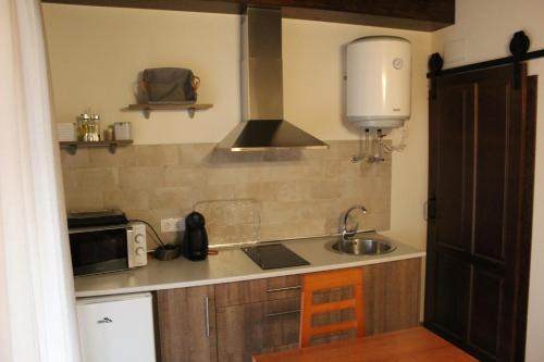 a small kitchen with a sink and a microwave at Alojamiento Rural La Estrella de David in Almagro