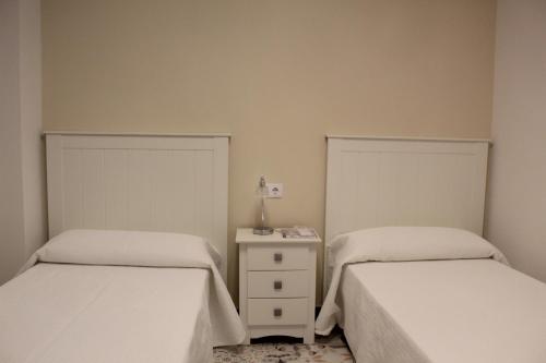 a bedroom with two beds and a night stand with a lamp at Alojamiento Rural La Estrella de David in Almagro