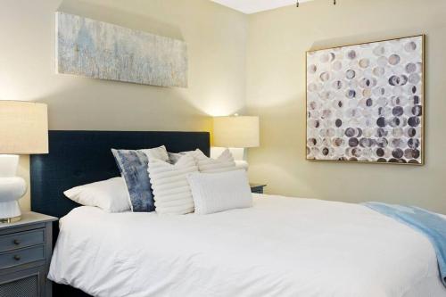 a bedroom with a large white bed with pillows at Desert Skyline Apt W/Pool & more in Phoenix