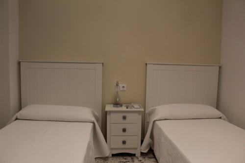 a bedroom with two beds and a table with a lamp at Alojamiento Rural La Estrella de David in Almagro