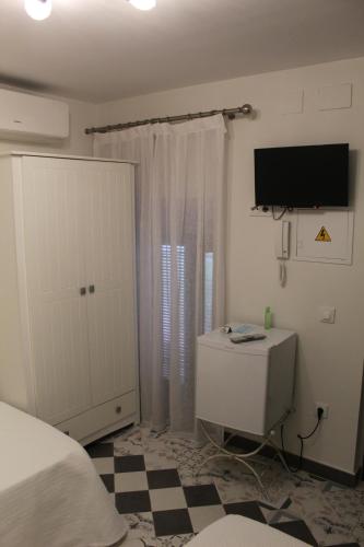 a bedroom with a bed and a flat screen tv at Alojamiento Rural La Estrella de David in Almagro