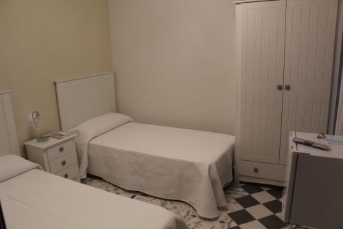 a small bedroom with two beds and a dresser at Alojamiento Rural La Estrella de David in Almagro