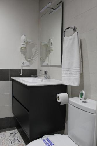 a bathroom with a sink and a toilet and a mirror at Alojamiento Rural La Estrella de David in Almagro