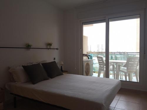 a bedroom with a bed and a balcony with a table at VENEZIOLA TRAVEL, relax & beach in La Manga del Mar Menor