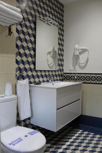 a bathroom with a toilet and a sink and a mirror at Alojamiento Rural La Estrella de David in Almagro