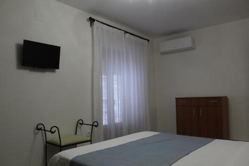a bedroom with a bed and a window with a television at Alojamiento Rural La Estrella de David in Almagro