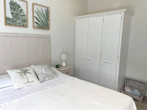 a bedroom with a white bed and a white closet at Modern 1 Bedroom Apartment - 3 min walk to beach in Saint James