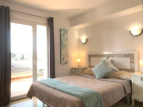 1 dormitorio con cama y ventana grande en Waterside Apartment - Two Bedroom en Ampuriabrava