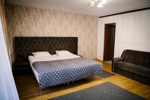 a bedroom with a large bed and a couch at Class in Petroşani
