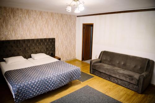 a bedroom with a bed and a couch at Class in Petroşani