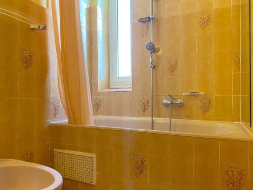 une salle de bain avec une baignoire, un lavabo et une fenêtre dans l'établissement Ajaccio, à Ajaccio