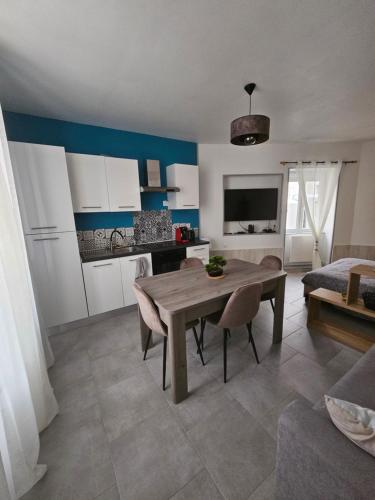 uma cozinha e sala de estar com uma mesa de madeira e cadeiras em Sarl la famille 2 em Angoulême