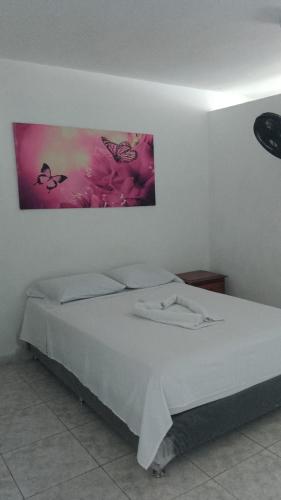 a bedroom with a bed with a painting on the wall at Hotel Bayadera Real in Medellín