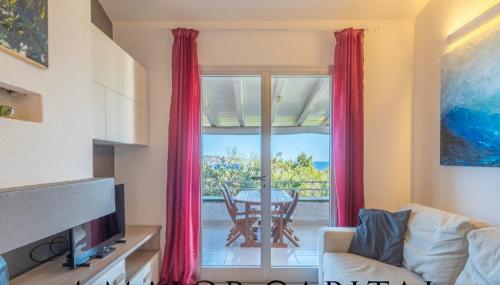 een woonkamer met een bank en een raam met een tafel bij MichHouse in San Teodoro