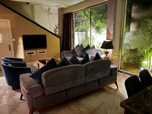 a living room with a couch and a television at Il Villaggio Luxury Villas in Jeddah