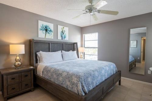 1 dormitorio con 1 cama y ventilador de techo en Coastal Condo Amazing Location! 50 Steps to the Beach, en Clearwater Beach