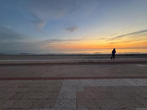 a person walking on the beach at sunset at LUZ Y MAR in Matalascañas
