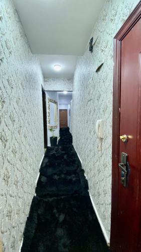 um corredor com um longo corredor com uma porta vermelha em شقة فندقية للإيجار في زهراء المعادي no Cairo