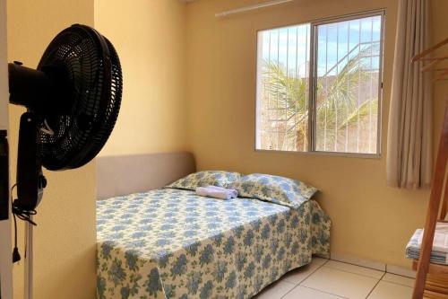a bedroom with a bed and a fan on the wall at Casa Completa e Bem Localizada in Parnaíba