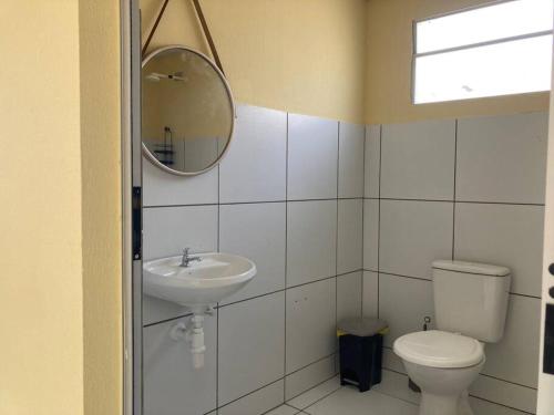 a bathroom with a sink and a toilet and a mirror at Casa Completa e Bem Localizada in Parnaíba