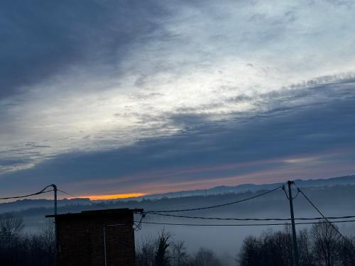 a cloudy sky with the sun setting in the distance at Il Fienile in Magliano Alpi