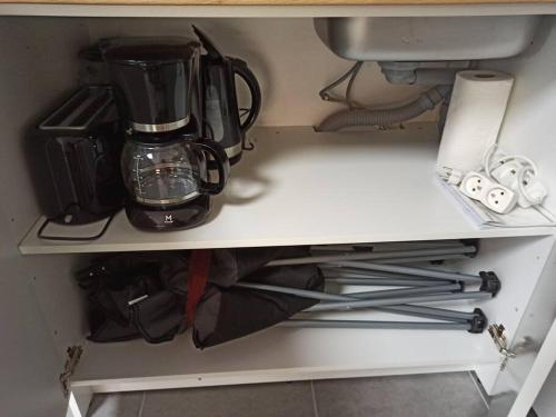 a cupboard with a blender and other items on it at Studio 4 pers, terrasse, clim, parking privé inclus in Cannes