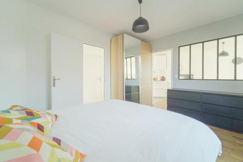 um quarto com uma grande cama branca e uma casa de banho em Quiet cosy and large apartment with Terrace Top location em Saint-Ouen