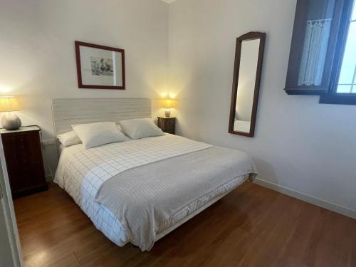 1 dormitorio con cama y espejo en la pared en Apartamento céntrico Plaza del Salvador, en Sevilla