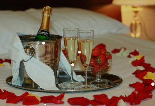 bandeja con copas de champán y fresas en la cama en La Tana Dell'OLMO en Fondi