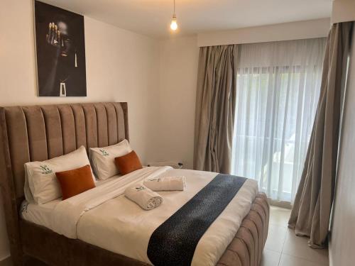 a large bed in a room with a large window at Astoria Luxury Apartments, Lavington in Nairobi