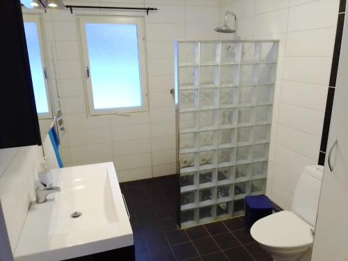 a bathroom with a sink and a toilet and a shower at Havsnära villa in Nordmaling