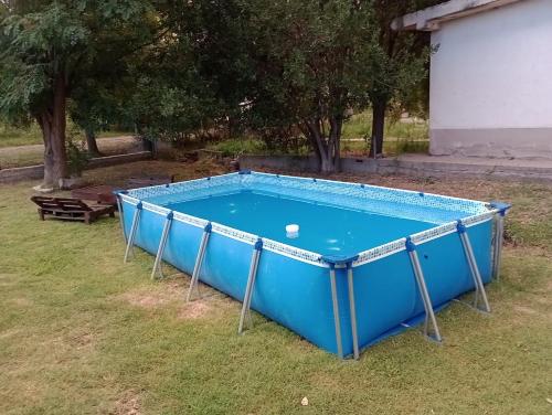 uma piscina azul na relva com uma bola dentro em Triana alquiler de casa para turista em San Rafael