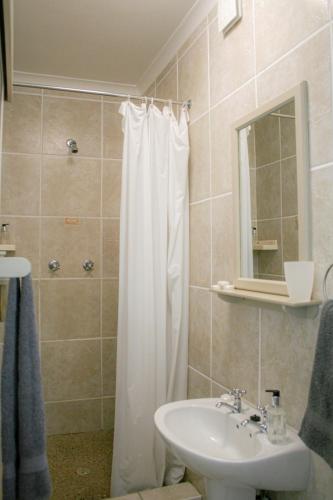 ein Badezimmer mit einem weißen Duschvorhang und einem Waschbecken in der Unterkunft Cozy Crner, home away from home, near from pristine beaches num2 in Langebaan