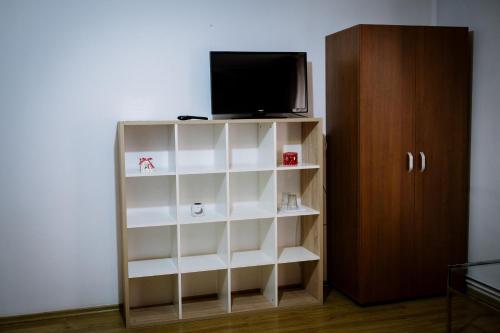 a white book shelf with a television on top at Class in Petroşani