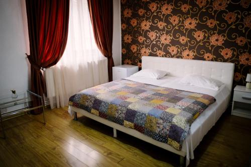 a bedroom with a bed with a quilt on it at Class in Petroşani