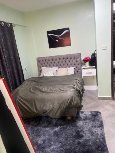 1 dormitorio con 1 cama con edredón gris en Trisha, en Bungoma