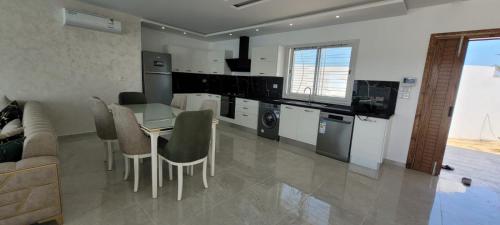 a kitchen with a table and chairs in a room at villa zak in Midoun