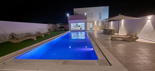 a swimming pool in a house at night at villa zak in Midoun