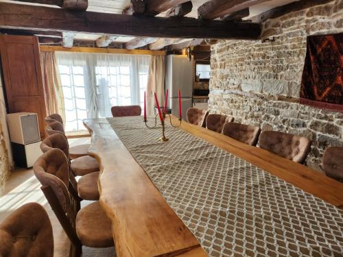 にあるКъща за гости Роден Балканのレンガ造りの壁の部屋の長い木製テーブル
