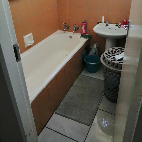 a bathroom with a bath tub and a sink at Room Blue in Pretoria