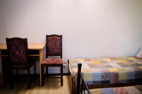 a bedroom with a bed and a table and chairs at Class in Petroşani