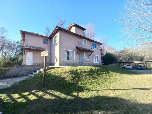 a house on a hill with a sign in front of it at Tantanakuy in Villa General Belgrano