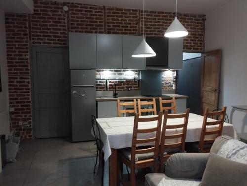 uma cozinha com mesa e cadeiras e uma cozinha com frigorífico em Charmante maison proche de toutes commodités em Croix