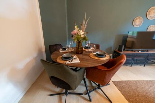 einen Esstisch mit Stühlen und eine Vase aus Blumen in der Unterkunft RR - Comfortable Apartment 60 qm - Central - WIFI in Magdeburg