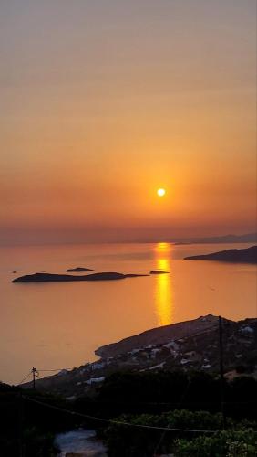 a sunset over a body of water at Aegean Mirror, Andros in Apróvaton