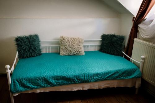 a bed with three pillows on it in a room at Class in Petroşani