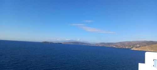 a large body of water with mountains in the background at Aegean Mirror, Andros in Apróvaton